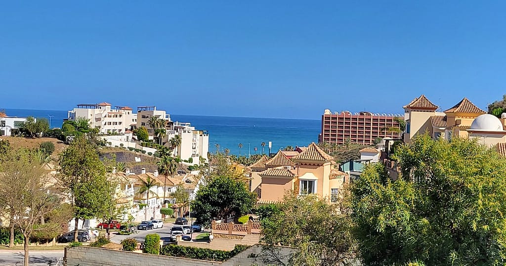 In a typical view for Benalmadena, the sea is seen through white, red, and yellow buildings 