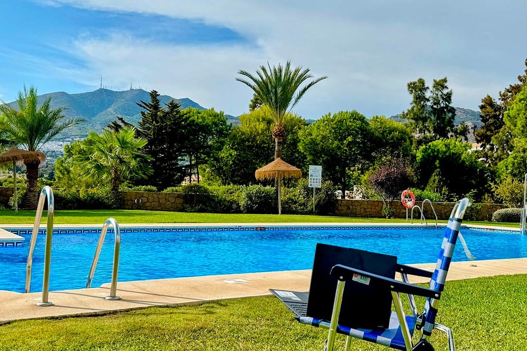 A laptop on a lounge chair in a picturesque setting typifies the allure of Spanish digital nomad visa 