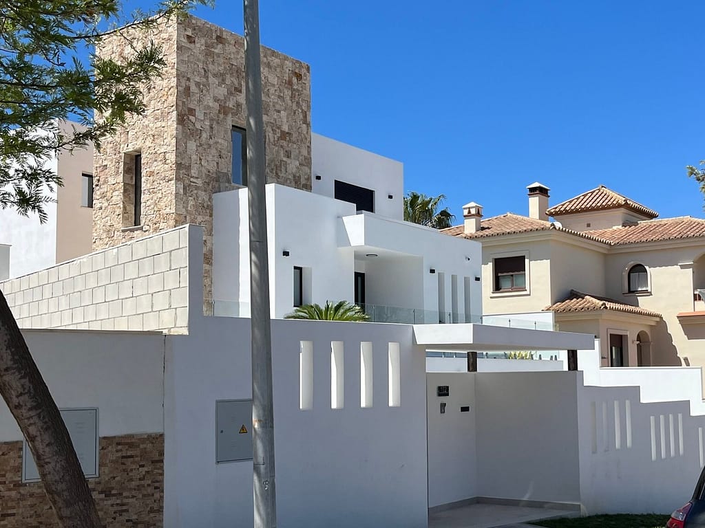 A modernist villa next to a traditional Spanish house 