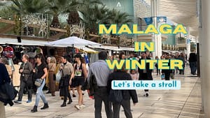 Malaga winter: On a warm December day people walk along the port promenade  